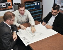 Preliminary Review Meeting with three people looking at architectural drawings